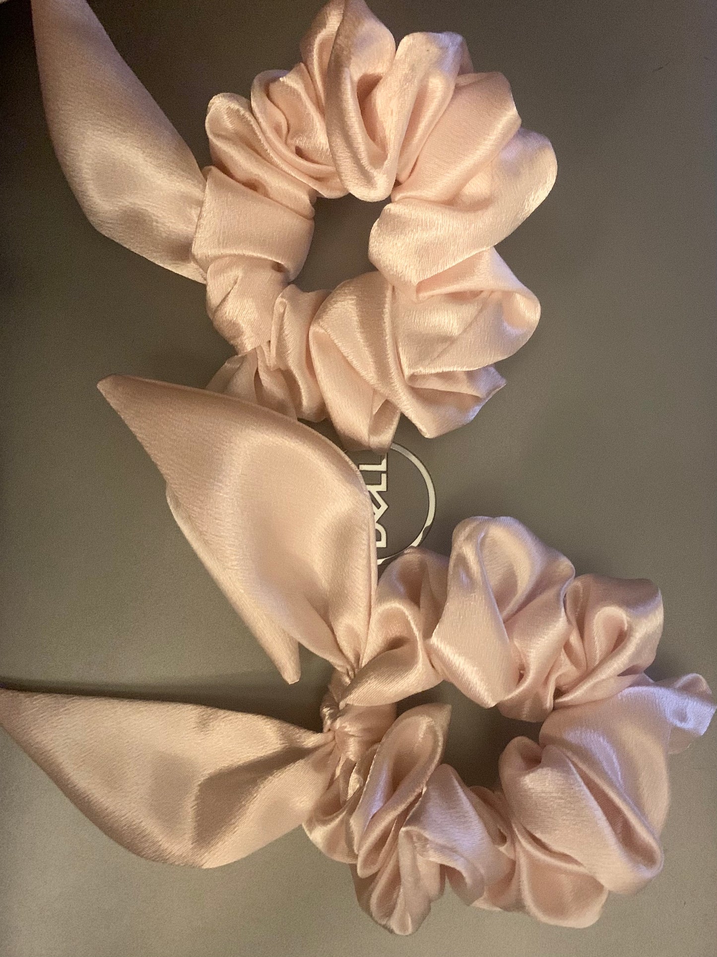 LW Designs hair scrunchies in various colors shown in a close-up image, highlighting soft fabric and elastic band details.