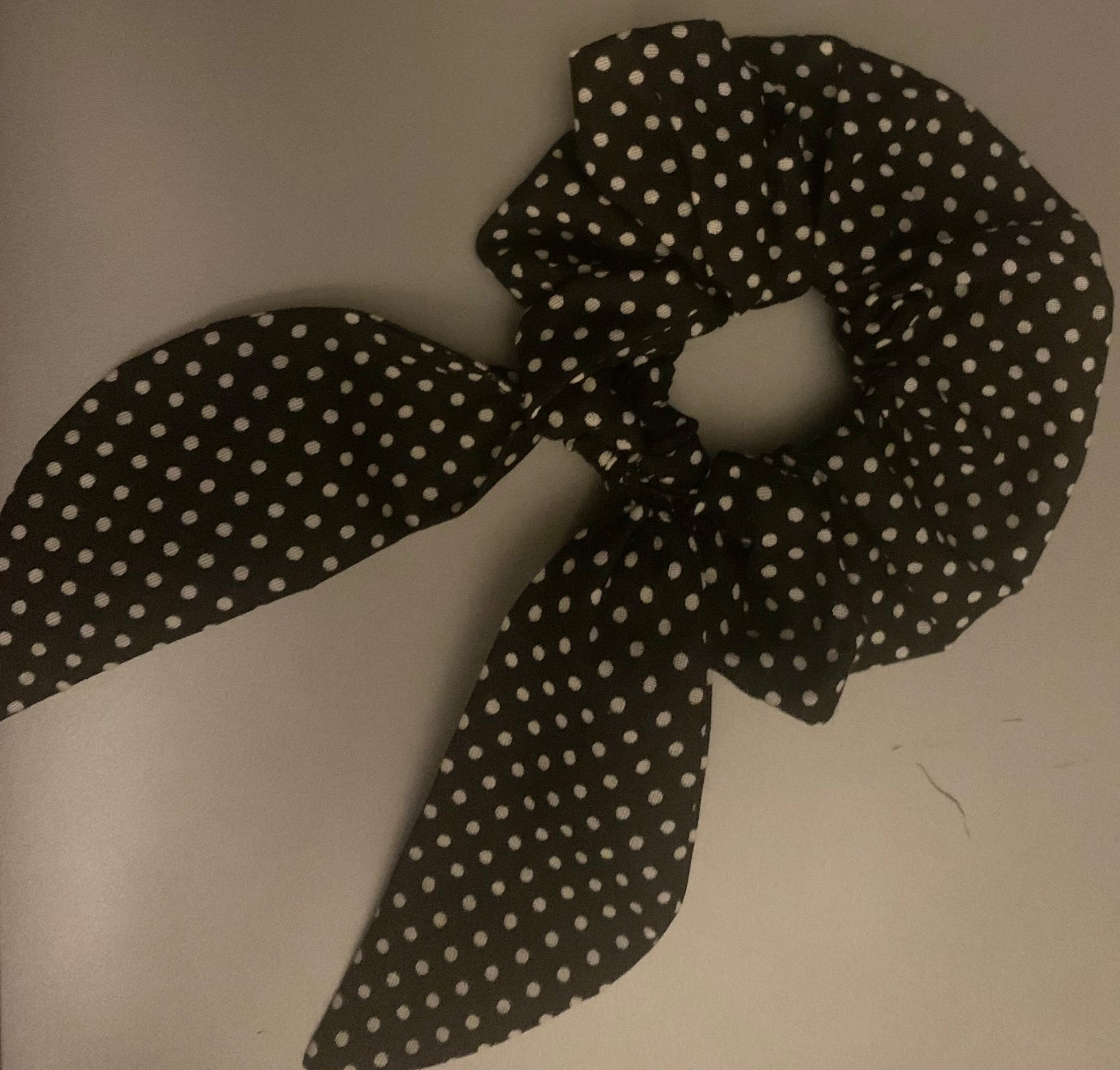 Light pink LW Designs hair scrunchies with soft fabric texture, shown coiled on a plain white background.