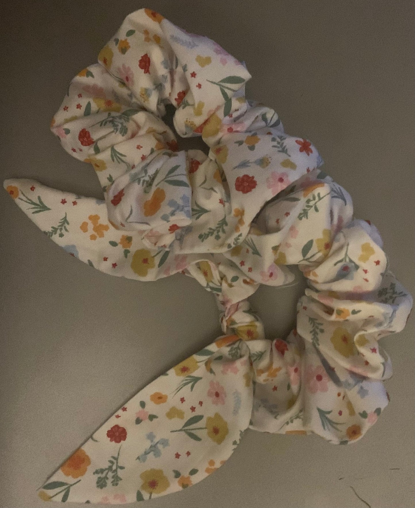 Light blue LW Designs hair scrunchies displayed on a white background, showing their soft fabric and elastic band.
