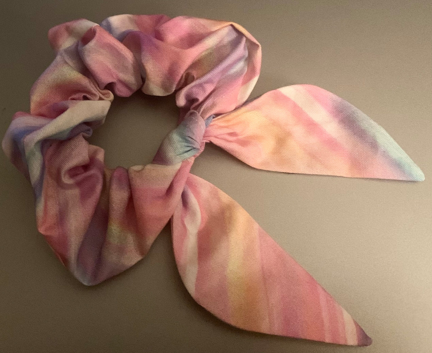 Light pink LW Designs hair scrunchies shown in a close-up image, showcasing soft fabric and elastic bands for styling.