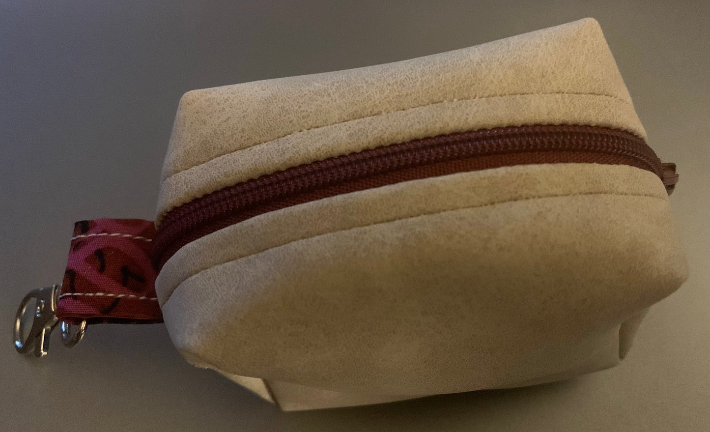 LW Designs poop bag holder featuring a compact, stylish design with a metal clip and colorful fabric for dog walks.