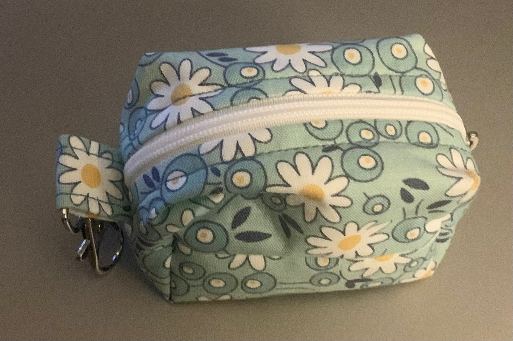 LW Designs poop bag holder with clip and loop, compact and stylish for carrying pet waste bags during walks.