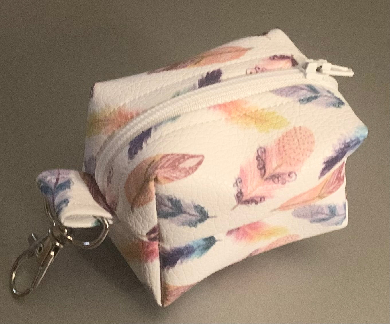 LW Designs poop bag holder attached to a leash, compact and stylish for carrying waste bags on walks.