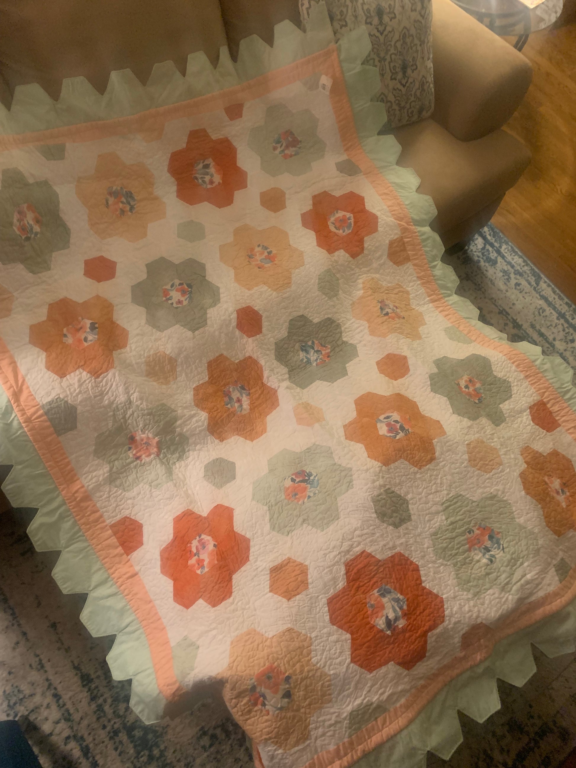 Light blue LW Designs throw size hexagon flower quilt with intricate quilted hexagon and floral patterns, cozy and decorative.