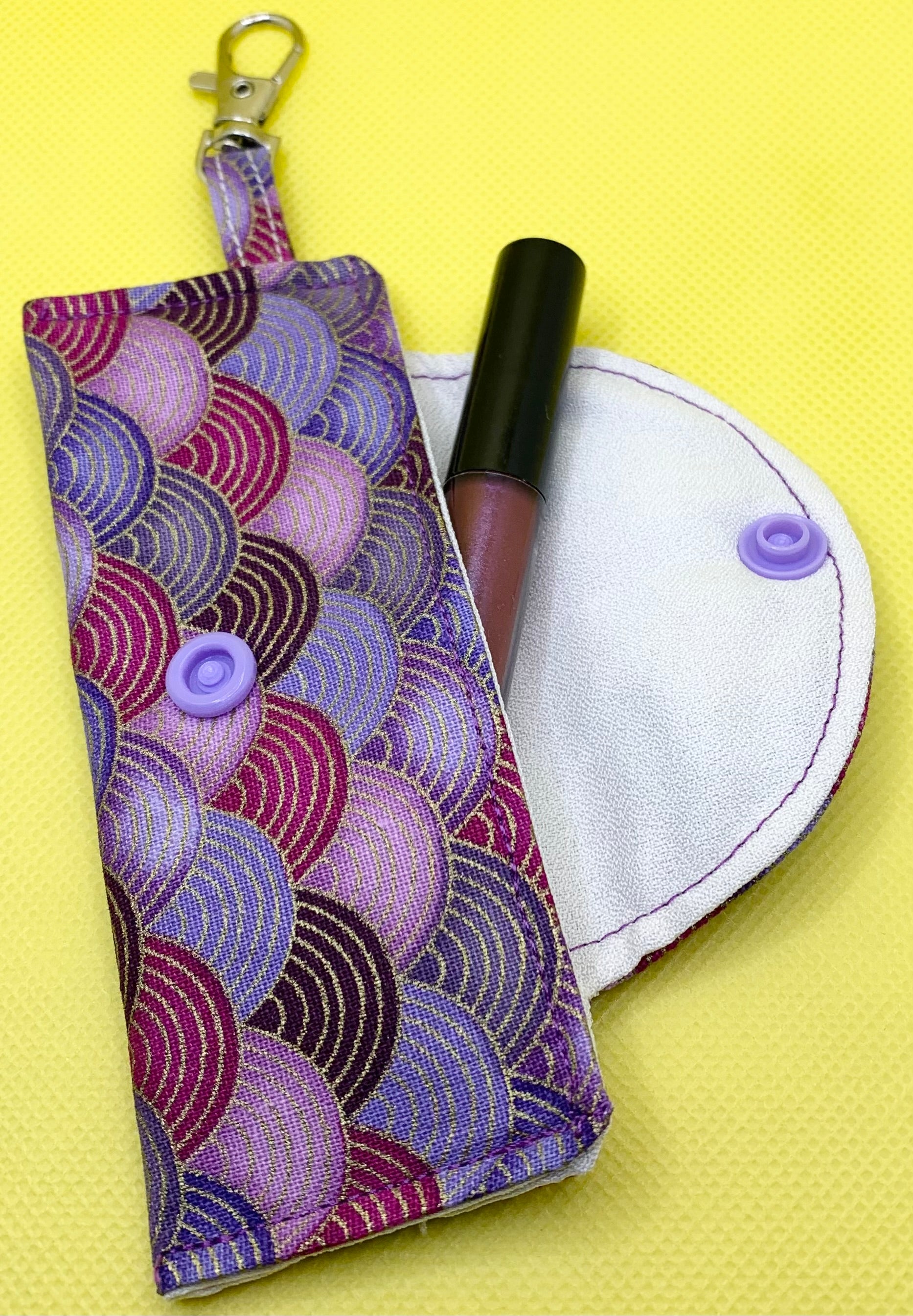 LW Designs lip balm holder attached to keychain, featuring a compact, colorful design for easy carrying and access.
