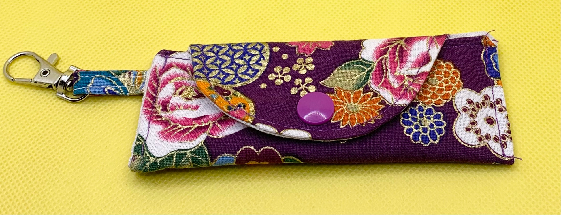 LW Designs lip balm holder displaying a colorful, durable case with a clip for easy attachment to bags or keychains.