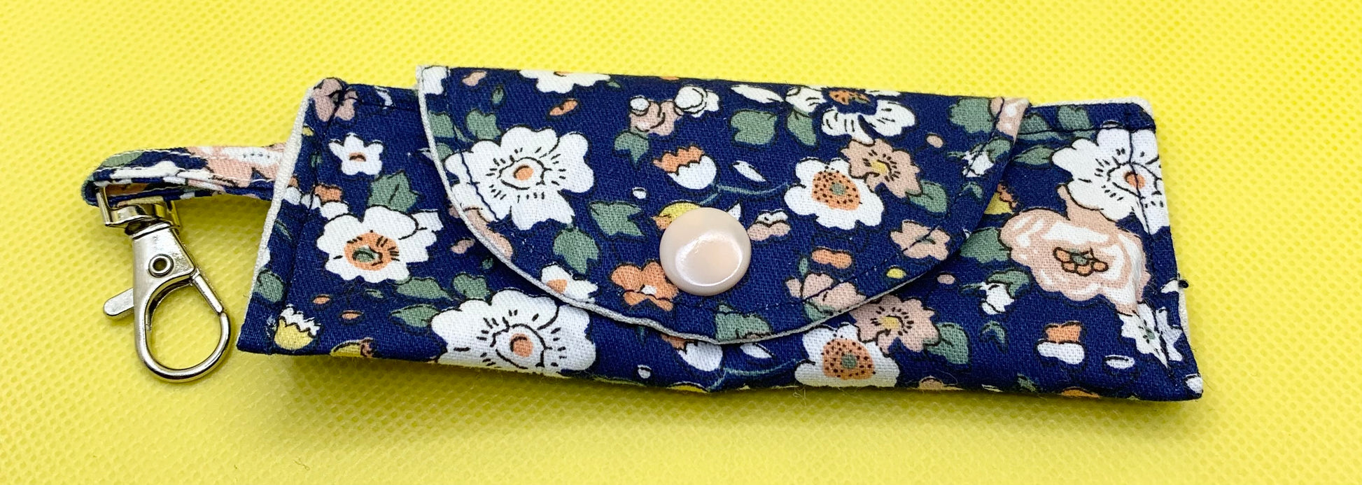 LW Designs lip balm holder with pink and white floral pattern, designed to securely hold chapstick or lip balm.